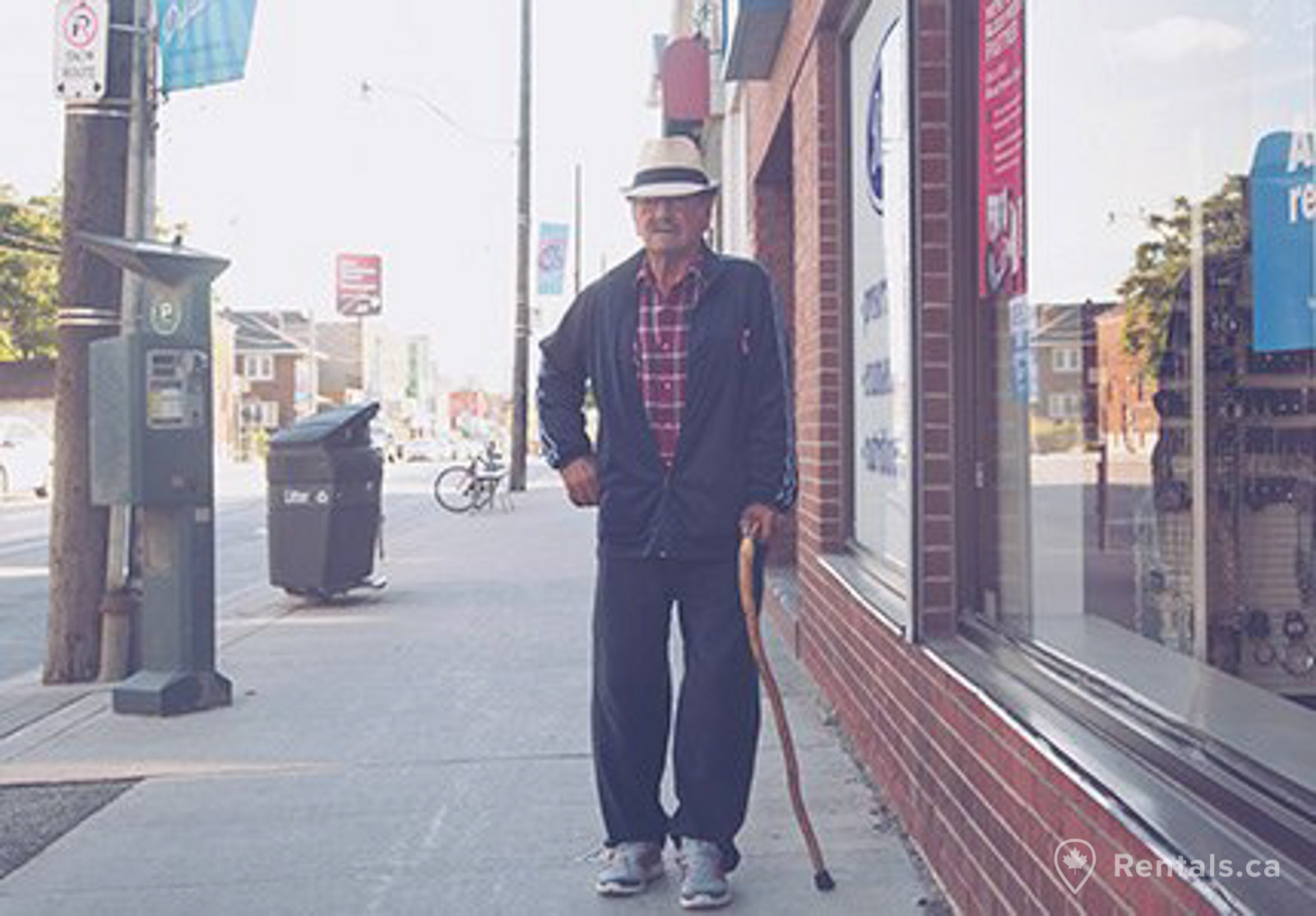 Man walking along side walk in Little Portugal Toronto near many homes for rent